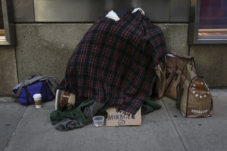 A homeless couple huddle together on 42nd Street in the Manhattan borough of New York, January 4, 2016. REUTERS/Carlo Allegri
