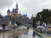 Visitors take photos at Disneyland in Anaheim, Calif., Friday, March 13, 2020. Disneyland is closing its doors for the rest of the month, shuttering one of California's best-known attractions as the state hurries to stop the spread of the coronavirus. (AP Photo/Amy Taxin)