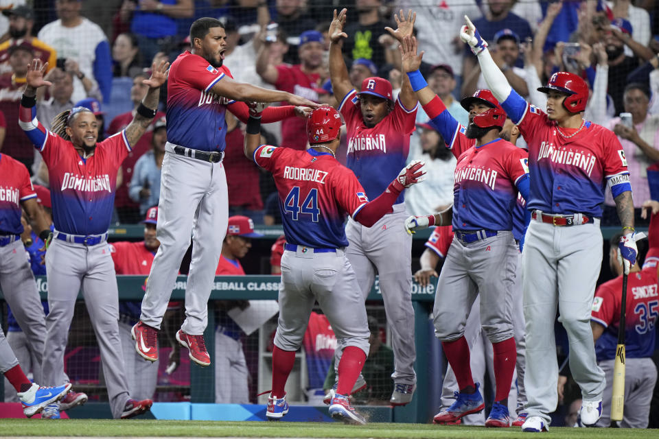 Dominican Republic's Julio Rodriguez (44) is congratulated by teammates after he scored on a double by Juan Soto during the first inning of a World Baseball Classic game against Venezuela, Saturday, March 11, 2023, in Miami. (AP Photo/Wilfredo Lee)