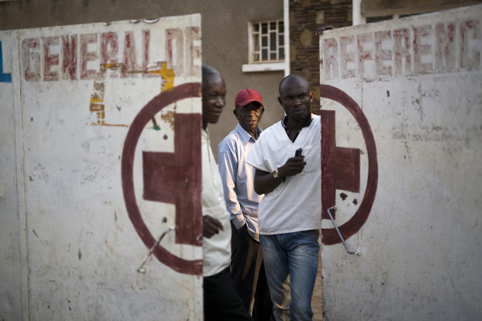 Employees guard the door of the Katuba Reference Hospital in Lubumbashi, Democratic Republic of the Congo on Monday, Aug. 13, 2018. An Associated Press investigation focused in Congo's second city, the copper-mining metropolis of Lubumbashi, discovered that of more than 20 hospitals and clinics visited, including this one, all but one detain patients unable to pay their bills. (AP Photo/Jerome Delay)