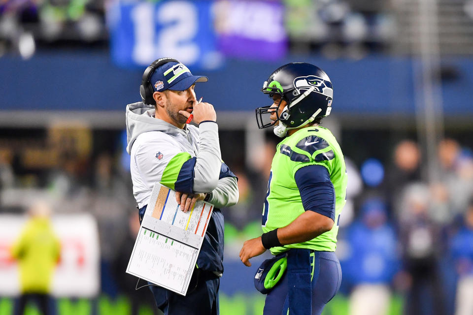 Russell Wilson chats with offensive coordinator Brian Schottenheimer during a game.