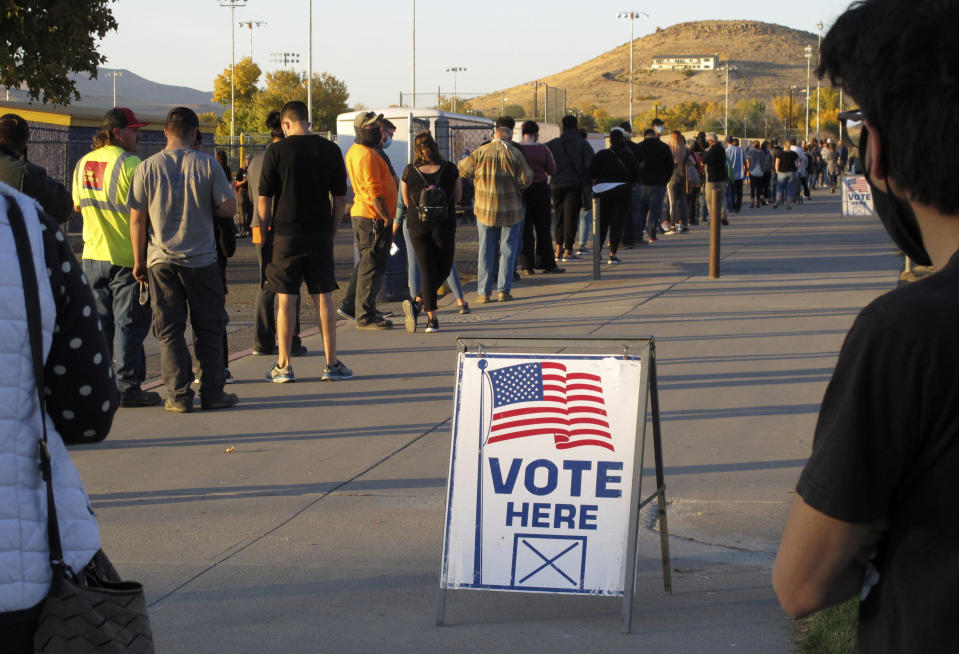 FILE - In this Nov. 3, 2020, file photo, mostly masked northern Nevadans wait to vote in-person at Reed High School in Sparks, Nev., prior to polls closing. U.S. officials say they found no evidence that foreign actors changed votes or otherwise disrupted the voting process in last November’s presidential election. That's according to government reports on March 16, 2021, affirming the integrity of the contest won by President Joe Biden. (AP Photo/Scott Sonner, File)