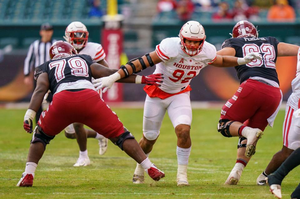 Houston defensive lineman Logan Hall (92) breaks through the line as he splits between Temple offensive linemen C.J. Perez (62) and Wisdom Quarshie (79) during the first half, Nov. 13, 2021, in Philadelphia. (AP Photo/Chris Szagola)