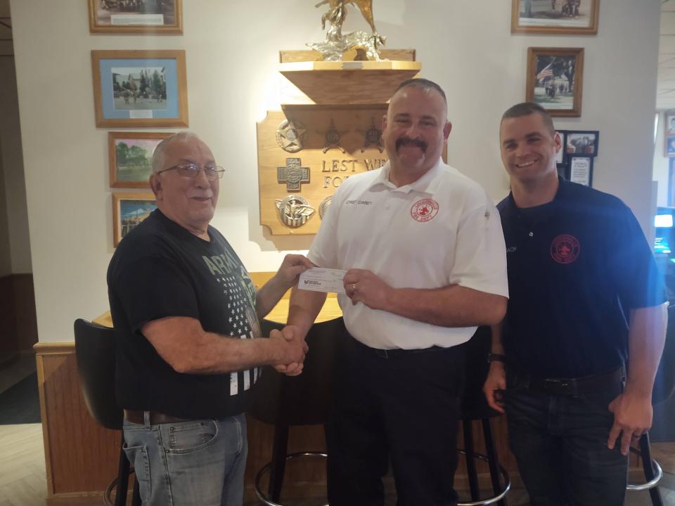 Don Riffle, first vice commander of American Legion Post 257 in Loudonville, presents a check fdor $15,982.98 to Chief Mike Carey and Jed Cronebach of the Loudonville Fire Department, the presentation made from funds raised through the Legion's charitable gifts account.