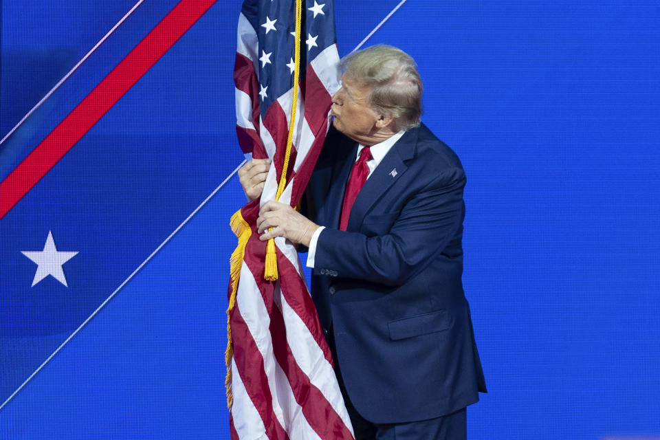 Trump kisses the American flag before speaking at CPAC on Saturday.