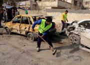 Baghdad municipality workers clean up after a car bomb attack near the Technology University in Sinaa Street in downtown Baghdad, Iraq, Wednesday, Jan. 15, 2014. A wave of bombings across Iraq striking busy markets and a funeral north of Baghdad killed tens of people Wednesday, authorities said, as the country remains gripped by violence after al-Qaida-linked militants took control of two cities in western Anbar province. (AP Photo/Karim Kadim)