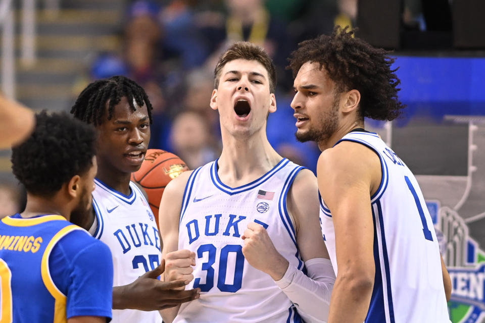 Mar 9, 2023; Greensboro, NC, USA; Duke Blue Devils center Kyle Filipowski (30) reacts with forward Mark Mitchell (25) and center Dereck Lively II (1) after scoring in the first half of the quarterfinals of the ACC tournament at Greensboro Coliseum.  Mandatory Credit: Bob Donnan-USA TODAY Sports