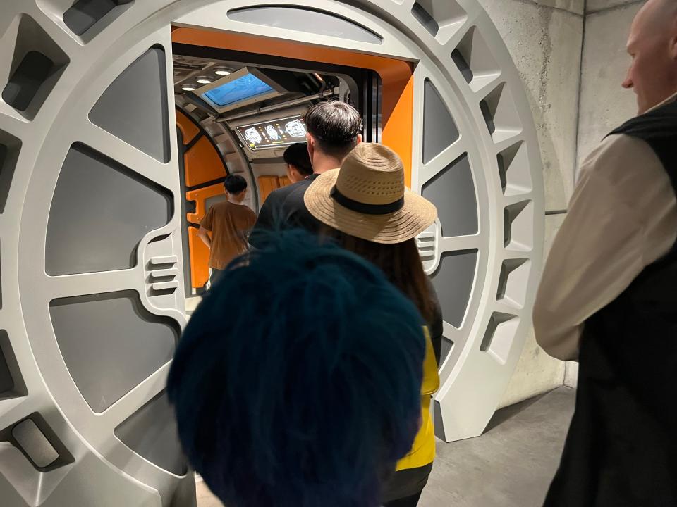 The Star Wars launch pod entrance with round doors and people filing in