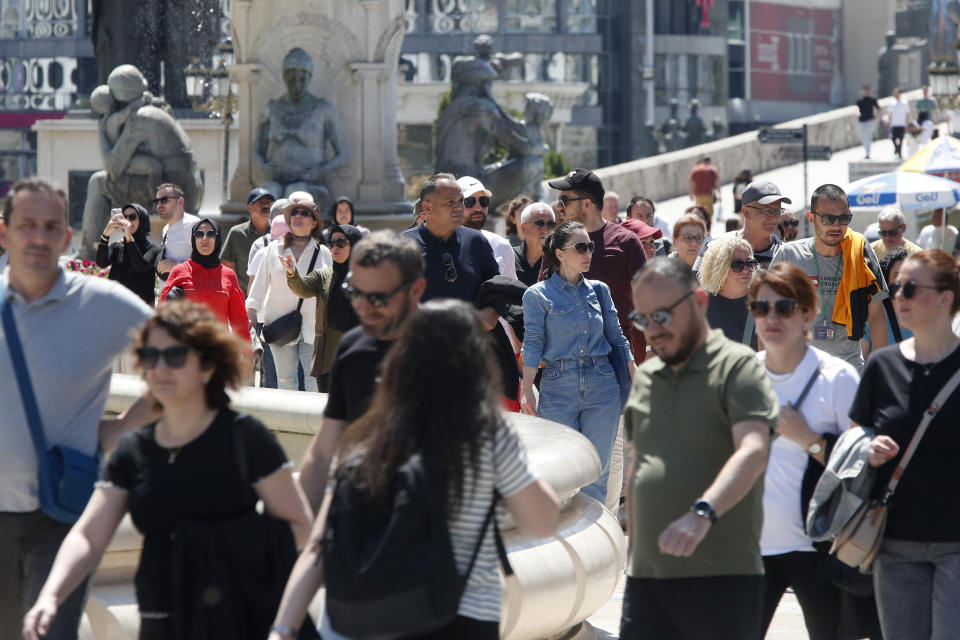 People walk through downtown Skopje, North Macedonia, on Monday, May 6, 2024. Voters go to the polls on Wednesday in North Macedonia to cast ballots for parliamentary election and presidential runoff, for the second time in two weeks. (AP Photo/Boris Grdanoski)