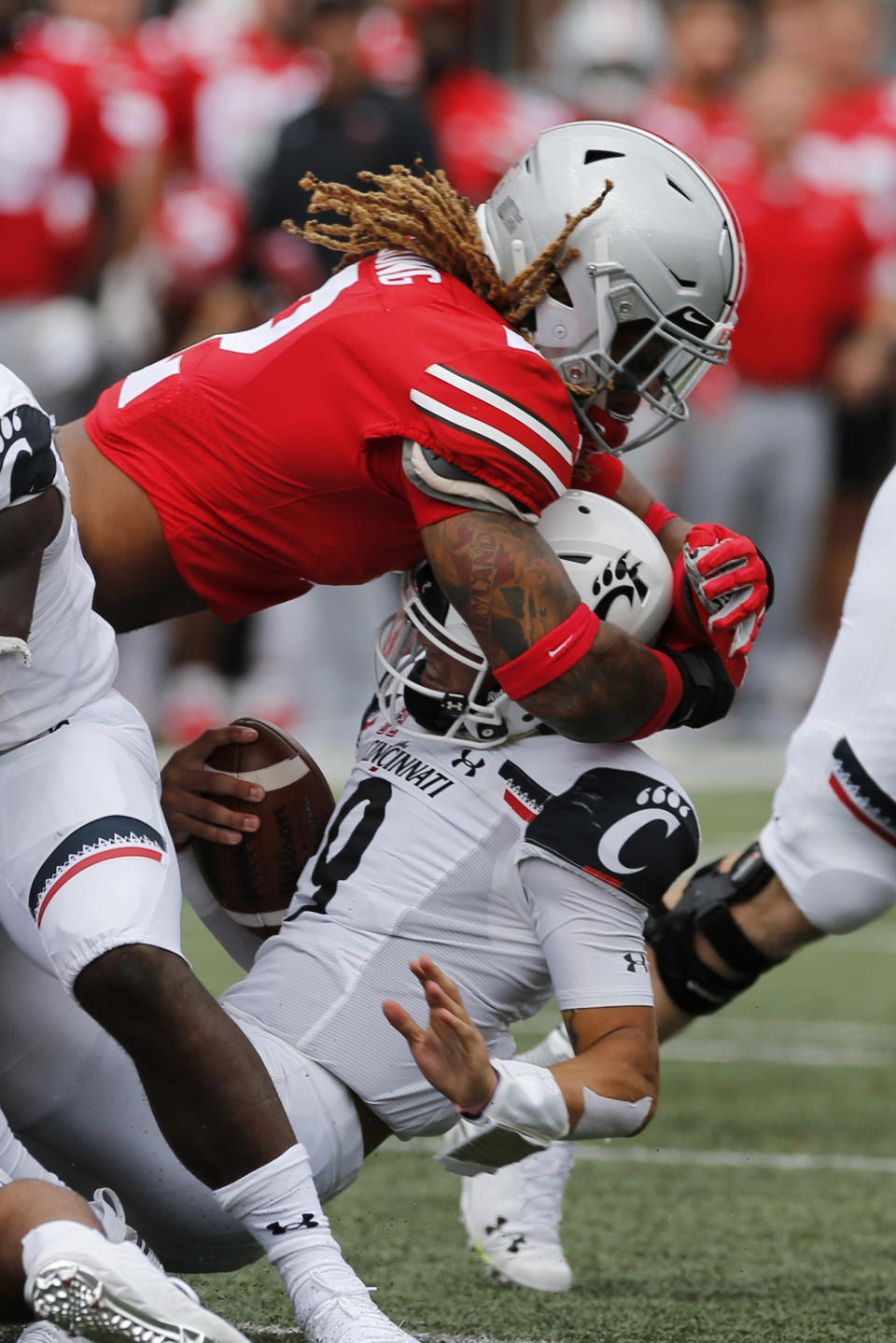 FILE - In this Sept. 7, 2019, file photo, Ohio State defensive end Chase Young, top, sacks Cincinnati quarterback Desmond Ridder during the first half of an NCAA college football game, in Columbus, Ohio. Ohio State said, Wednesday, Nov. 13, 2019, the NCAA has concluded that star DE Chase Young must sit out one more football game before he can return. (AP Photo/Jay LaPrete, File)