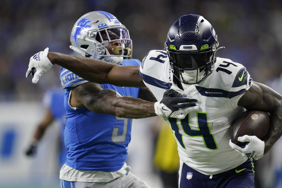 Seattle Seahawks wide receiver DK Metcalf (14) pushes Detroit Lions safety DeShon Elliott (5) during the first half of an NFL football game, Sunday, Oct. 2, 2022, in Detroit. (AP Photo/Paul Sancya)