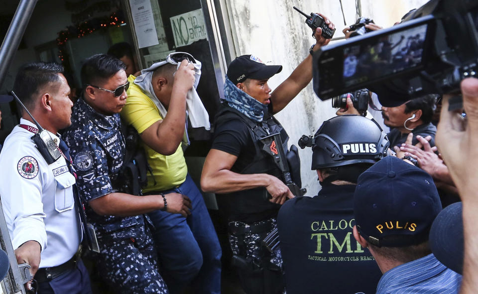 One of three police officers are escorted out of the courtroom after being found guilty and sentenced up to 40 years without parole for the killing of a student Thursday, Nov. 29, 2018, in suburban Caloocan city, north of Manila, Philippines. The court found the three police officers guilty on Thursday of killing Kian Loyd Delos Santos, a student they alleged was a drug dealer, in the first known such conviction under the president's deadly crackdown on drugs. (AP Photo/Gerard Carreon)