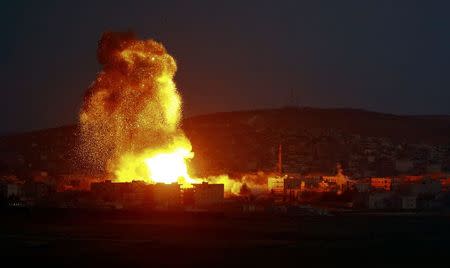 Smoke and flames rise over Syrian town of Kobani after an airstrike, as seen from the Mursitpinar border crossing on the Turkish-Syrian border in the southeastern town of Suruc in Sanliurfa province, October 18, 2014. REUTERS/Kai Pfaffenbach