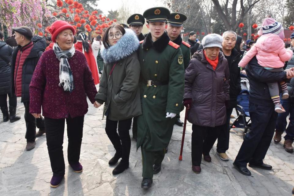 Chinese paramilitary police officers make their way through the crowds during New Year celebrations in Beijing.