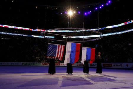 Figure Skating - ISU World Figure Skating Championships - Ladies Free Skate program - Boston, Massachusetts, United States - 02/04/16 - The flags of silver medalist Ashley Wagner of the United States, gold medalist Evgenia Medvedeva of Russia and bronze medalist Anna Pogorilaya of Russia are raised during the awards ceremony. REUTERS/Brian Snyder