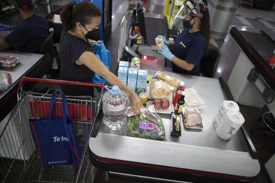 A woman checks out at a supermarket in Caracas, Venezuela, Friday, June 4, 2021. Two years ago Venezuela stopped restricting transactions in dollars, which has largely ended shortages but has meant many Venezuelans who are paid in bolivars can't afford what's on those shelves. ( AP Photo/Ariana Cubillos)