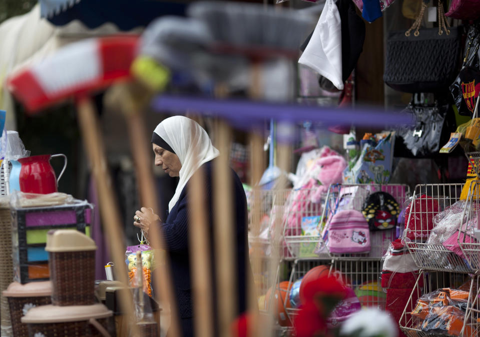 An Israeli Arab woman buys goods in a shop in the Arab town of Taybeh, central Israel,Thursday, Jan. 9, 2014. A new proposal by Israel's powerful and outspoken foreign minister has sparked outrage among the country's Arab minority and added new complications to U.S. Secretary of State John Kerry's long shot Mideast peace mission. Avigdor Lieberman, the prime minister's top political ally, says he will oppose any peace plan that doesn't redraw Israel's borders to move large chunks of Israeli Arabs into a future Palestine. While the idea faces many obstacles, it has already managed to enrage Israeli Arabs who see it as another reminder of their second-class status in the Jewish state and a rejection of their national identity and bond to Palestinians living in the West Bank and beyond. (AP Photo/Ariel Schalit)