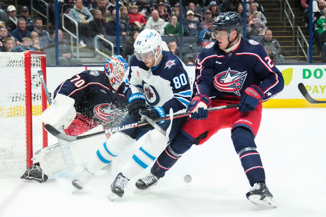 Feb 16, 2023; Columbus, Ohio, USA;  Columbus Blue Jackets goaltender Joonas Korpisalo (70) turns away a shot from Winnipeg Jets left wing Pierre-Luc Dubois (80) defended by left wing Patrik Laine (29) during the second period of the NHL hockey game at Nationwide Arena. Mandatory Credit: Adam Cairns-The Columbus Dispatch