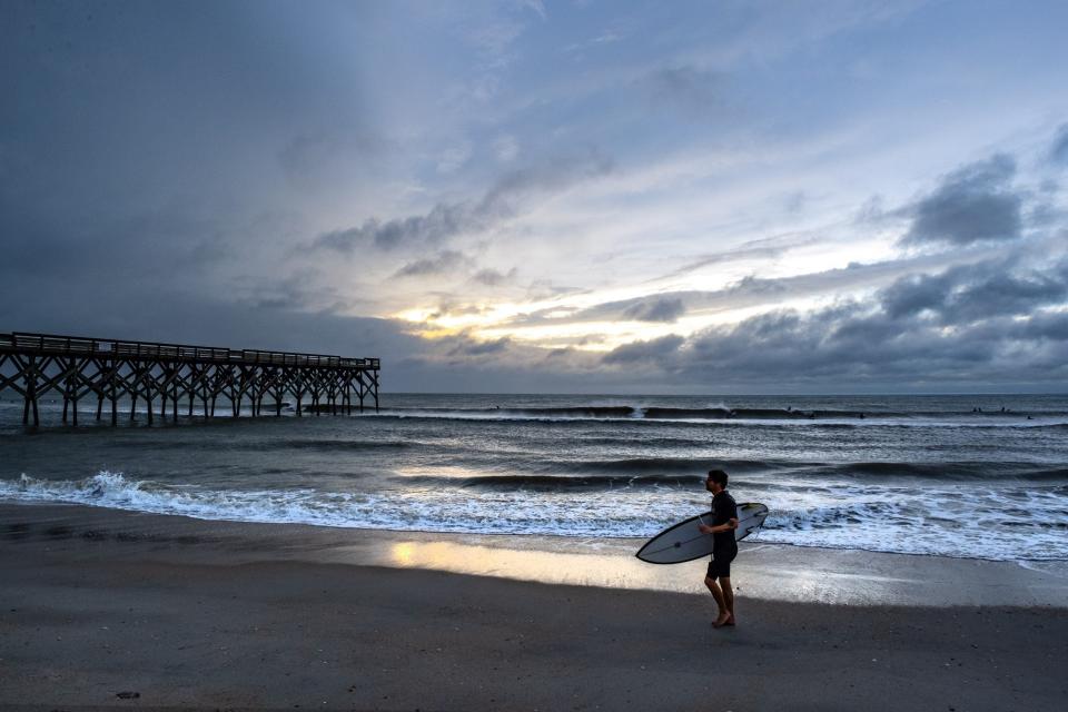 File: Surfers ride the waves at Wrightsville Beach. (Photo by Eros Hoagland/Getty Images)