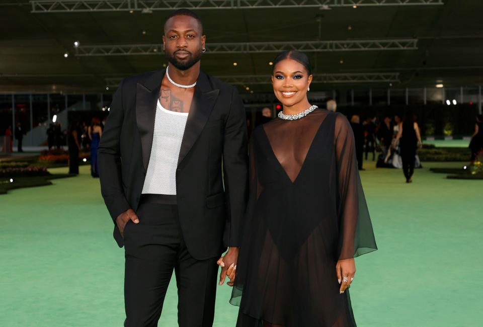 The couple dressed in black looking at the camera and smiling