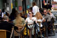 FILE PHOTO: People relax at outdoor dining areas as lockdown restrictions continue to ease in London