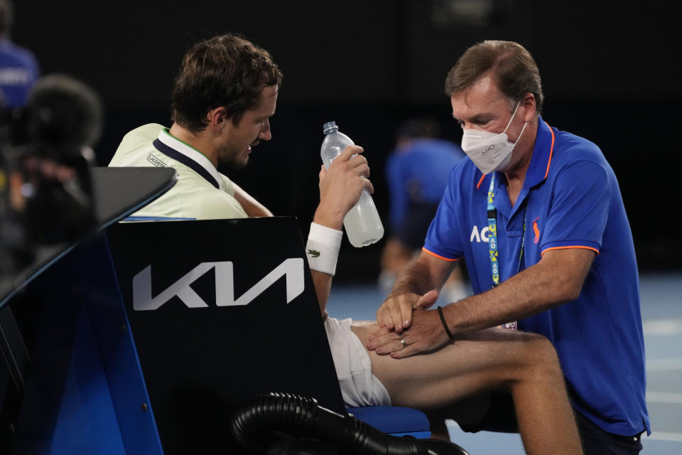 Daniil Medvedev of Russia receives treatment from a trainer during his men's singles final match against Rafael Nadal of Spain at the Australian Open tennis championships in Melbourne, Australia, Sunday, Jan. 30, 2022. (AP Photo/Simon Baker)