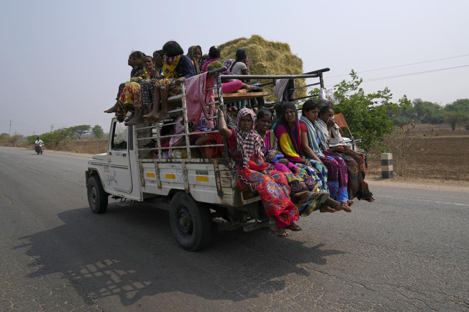 A group of women travel in a mini truck on a hot summer day in Raichur, India, Thursday, April 20, 2023. (AP Photo/Aijaz Rahi)