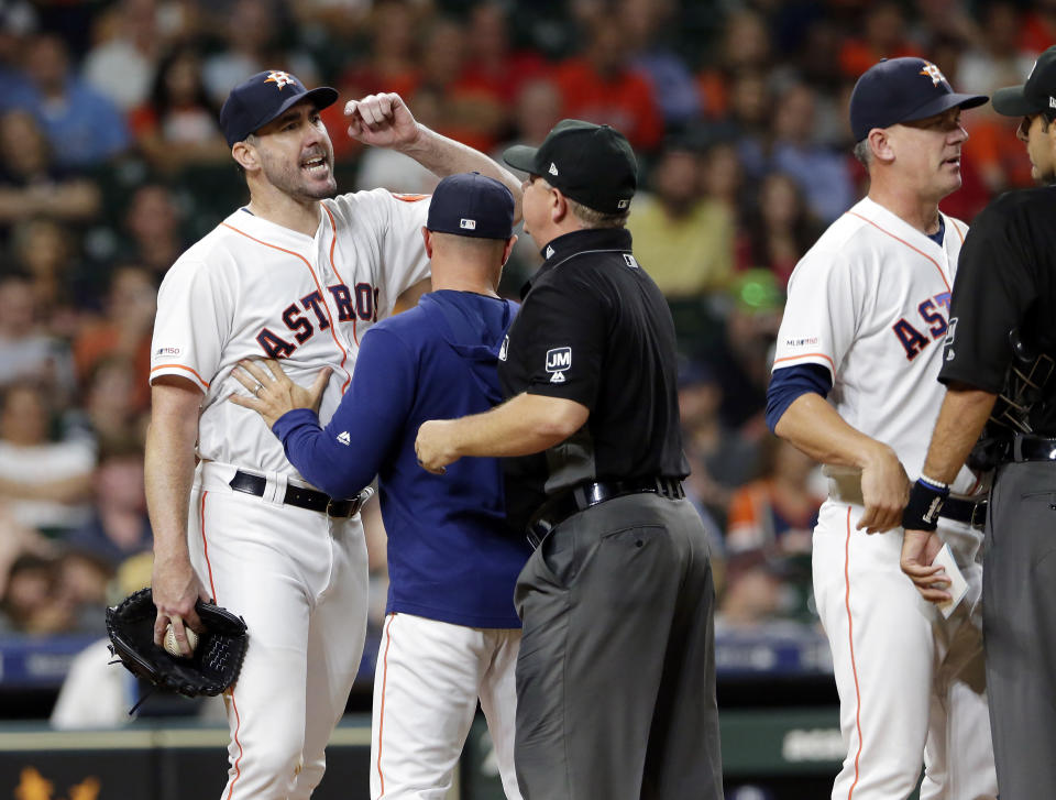 Houston Astros starting pitcher Justin Verlander, left, yells at home plate umpire Pat Hoberg, right, as Joe Espada, first base umpire Greg Gibson and manger A.J. Hinch get between them after Verlander was ejected by Hoberg during the sixth inning of a baseball game against the Tampa Bay Rays Tuesday, Aug. 27, 2019, in Houston. (AP Photo/Michael Wyke)