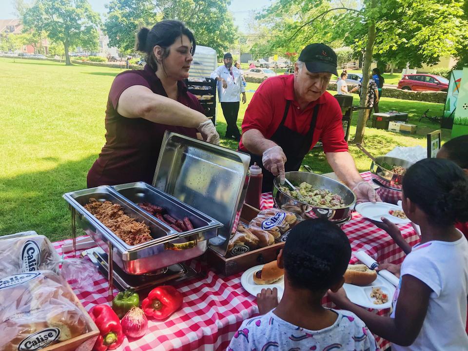 Two Chartwells employees serve up free barbecue lunches at the kickoff event held in 2019 at Miantonomi Park for the Newport Public Schools Summer Meals Program.