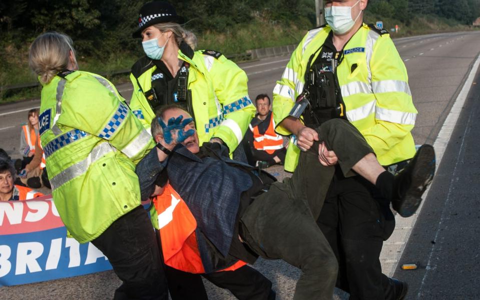 Police remove activists from the motorway as protestors from Insulate Britain block the M25 motorway - Guy Smallman/Getty Images