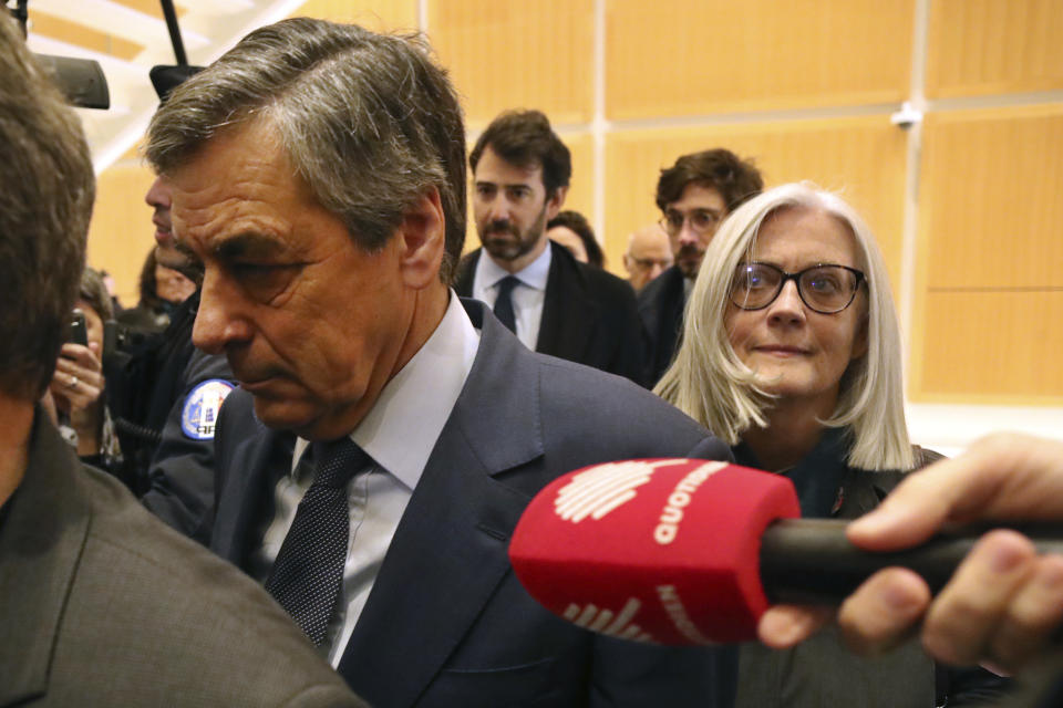 France's former Prime Minister Francois Fillon, left, and his wife Penelope, arrive at the Paris courthouse, in Paris, Wednesday, Feb. 26, 2020. He could have been president of France. Instead, former Prime Minister Francois Fillon is going on trial to face fraud charges after he used public funds to richly pay his wife and children for work they allegedly never performed. (AP Photo/Thibault Camus)