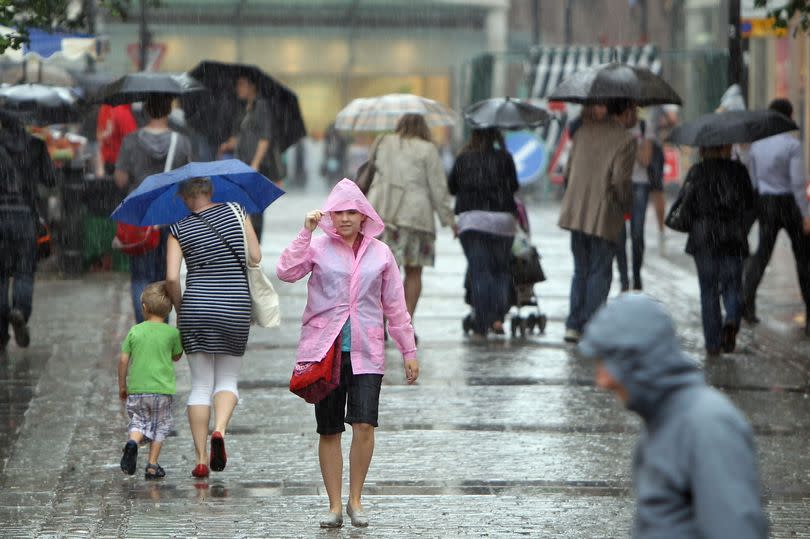 People walk through Covent Garden during a downpour