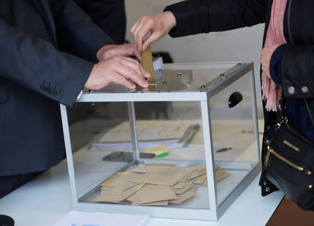 A woman casts her vote during the second round of the 2017 French presidential election at a polling station inside the Lycee Francais Charles de Gaulle school, in London, Britain May 7, 2017. REUTERS/Hannah McKay