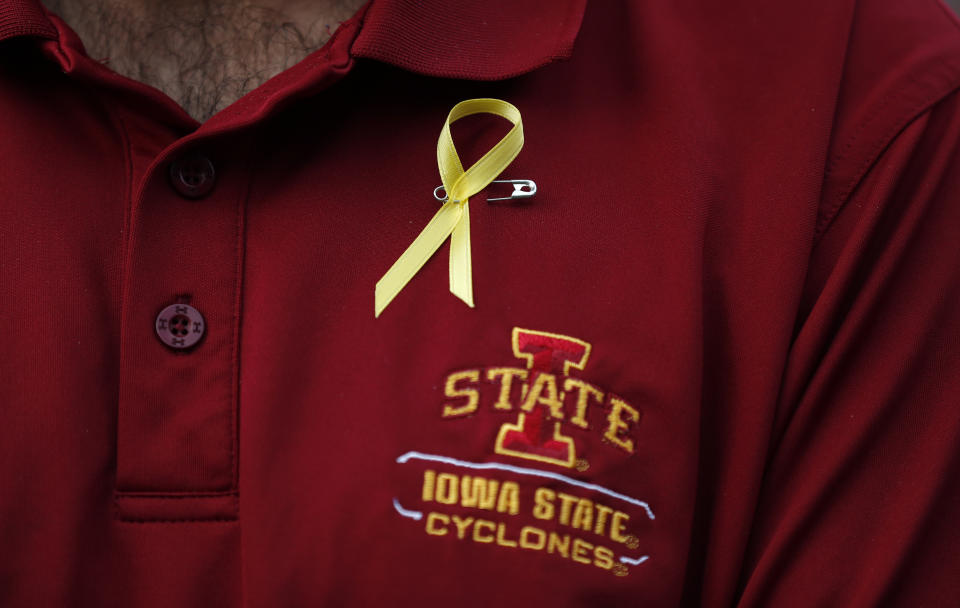 A vigil attendee wears a yellow ribbon in honor of slain Iowa State University student Celia Barquin Arozamena, Wednesday, Sept. 19, 2018, in Ames, Iowa. Barquin, who was the 2018 Big 12 women's golf champion and Iowa State Female Athlete of the Year, was found Monday morning in a pond at a golf course near the Iowa State campus. (AP Photo/Charlie Neibergall)