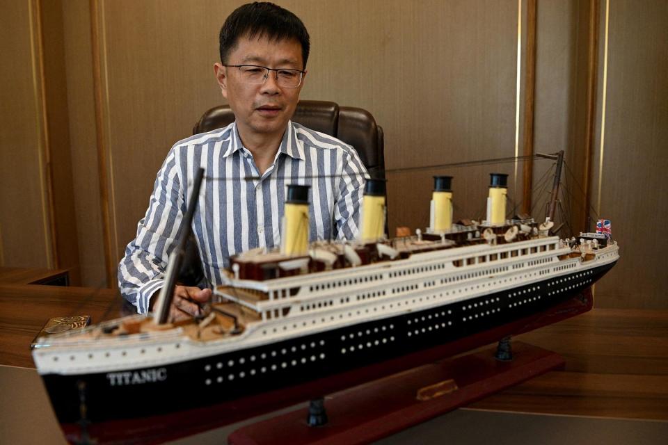 An investor helping to build a life-size replica of the Titanic, next to a model of the ship