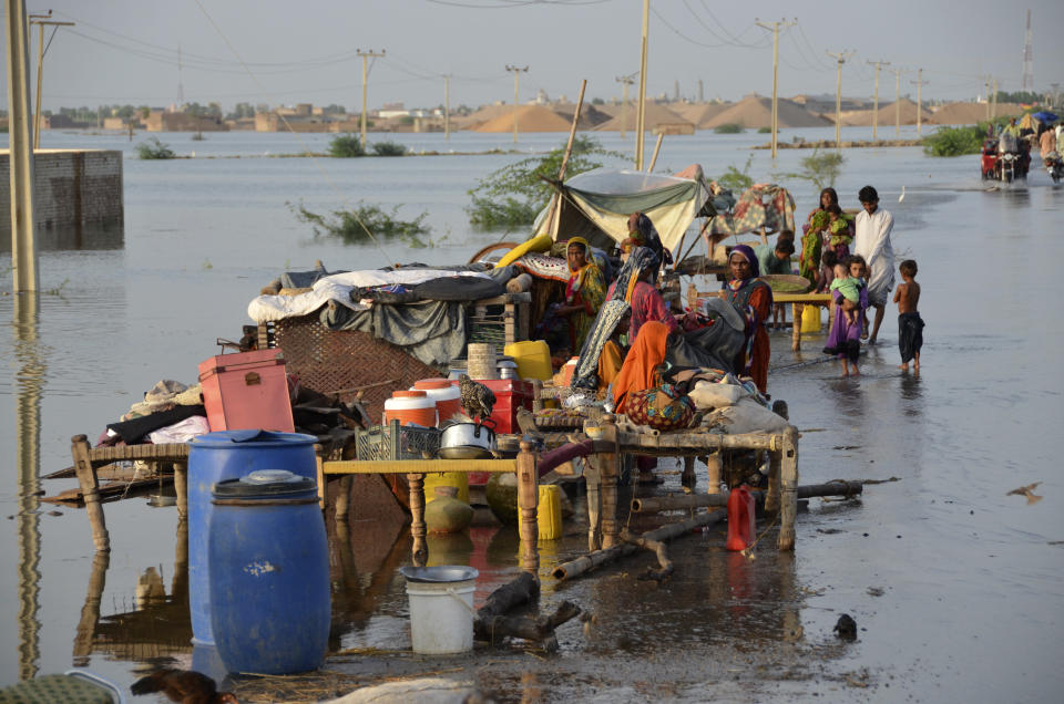 FILE - Families sit near their belongings surrounded by floodwaters, in Sohbat Pur city of Jaffarabad, a district of Pakistan's southwestern Baluchistan province, Aug. 28, 2022. The flooding has all the hallmarks of a catastrophe juiced by climate change, but it is too early to formally assign blame to global warming, several scientists tell The Associated Press. (AP Photo/Zahid Hussain, File)