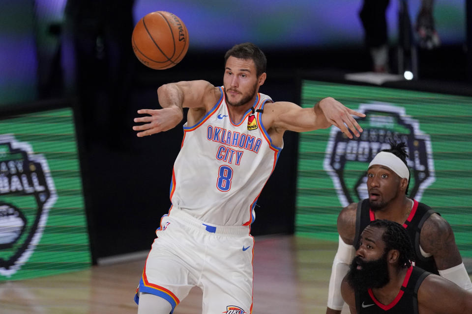 Oklahoma City Thunder's Danilo Gallinari (8) passes the ball as Houston Rockets' James Harden, bottom right, and Robert Covington, right rear, look on during the second half of an NBA first-round playoff basketball game in Lake Buena Vista, Fla., Wednesday, Sept. 2, 2020. (AP Photo/Mark J. Terrill)