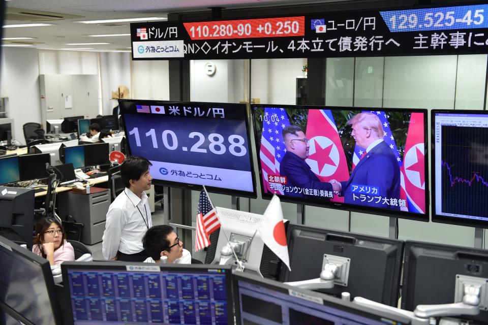 <p>Employees of a foreign exchange trading company in Tokyo watch live news of the summit in Singapore and the Japanese yen’s exchange rate against the U.S. dollar on Tuesday. (Photo: Kazuhiro Nogi/AFP/Getty Images) </p>