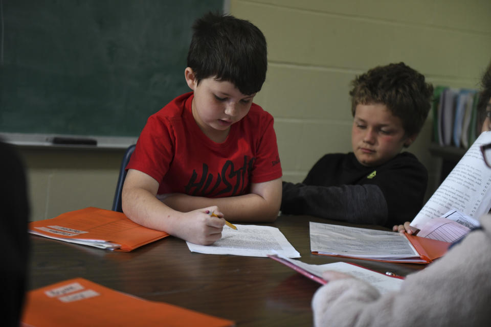 Third grader Parker, left, and a classmate at Highland Elementary School in Columbus, Kan., practice reading on April 12, 2023. After falling behind in the early days of the pandemic, Parker started this school year reading at the level of a first grader. He did months of phonics drills and small-group work, and made tremendous progress. "I actually do like reading now," Parker said. (AP Photo/Nicholas Ingram)