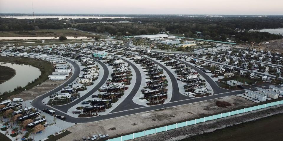 A bird's eye view of Camp Margaritaville RV Resort and Cabana Cabins in Auburndale, Florida at sunset. There are rows of parked RVs and cabins.