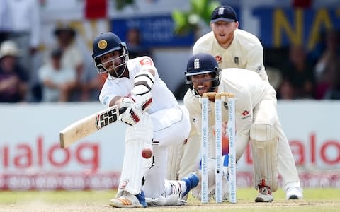 Sri Lanka's Kusal Mendis (L) plays a shot as England's wicketkeeper Ben Foakes (bottom R) looks on during the fourth day of the opening Test match between Sri Lanka and England at the Galle International Cricket Stadium - Credit: ISHARA S. KODIKARA / AFP