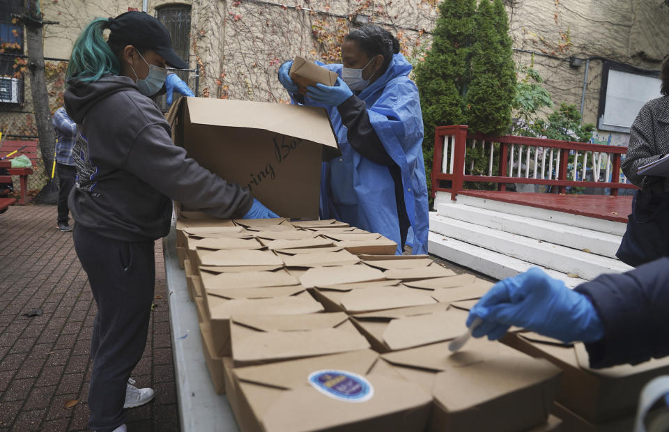 Volunteers unload boxed meals prepared at the South Bronx restaurant La Morada, Oct. 28, 2020, in New York. After a fund raising campaign during the coronavirus pandemic, La Morada, an award winning Mexican restaurant, was reopened and now also functions as a soup kitchen, serving 650 meals daily. (Bebeto Matthews / AP)