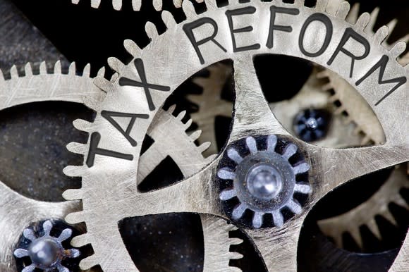 Metal clockwork gears with the words Tax Reform engraved on the side.