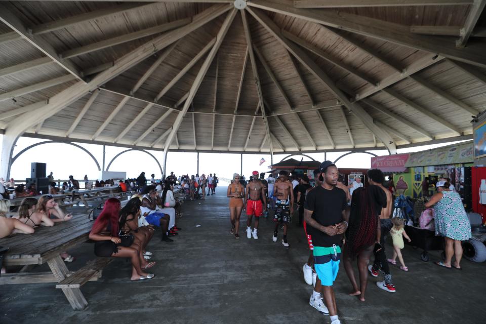 Beach goers walk around the Tybee Island Pier and Pavilion on Saturday, July 1, 2023 on Tybee Island, GA. An advertised event called Turnt Island was not permitted and unorganized.