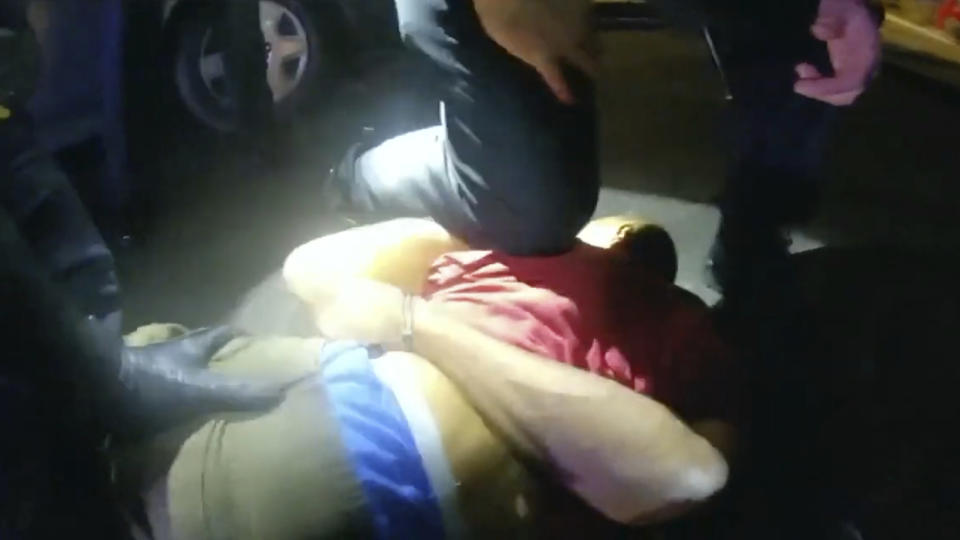 In this image from Chula Vista Police Department body-camera video, officers restrain Oral Nunis, 56, after he ran out of his daughter’s California apartment in 2020. Although his body turned still, police kept pressing and even wrapped him in a full-body restraint device. From just 10 feet away, his daughter tried to console him in his final minutes: “Daddy, just breathe.” (Chula Vista Police Department via AP)