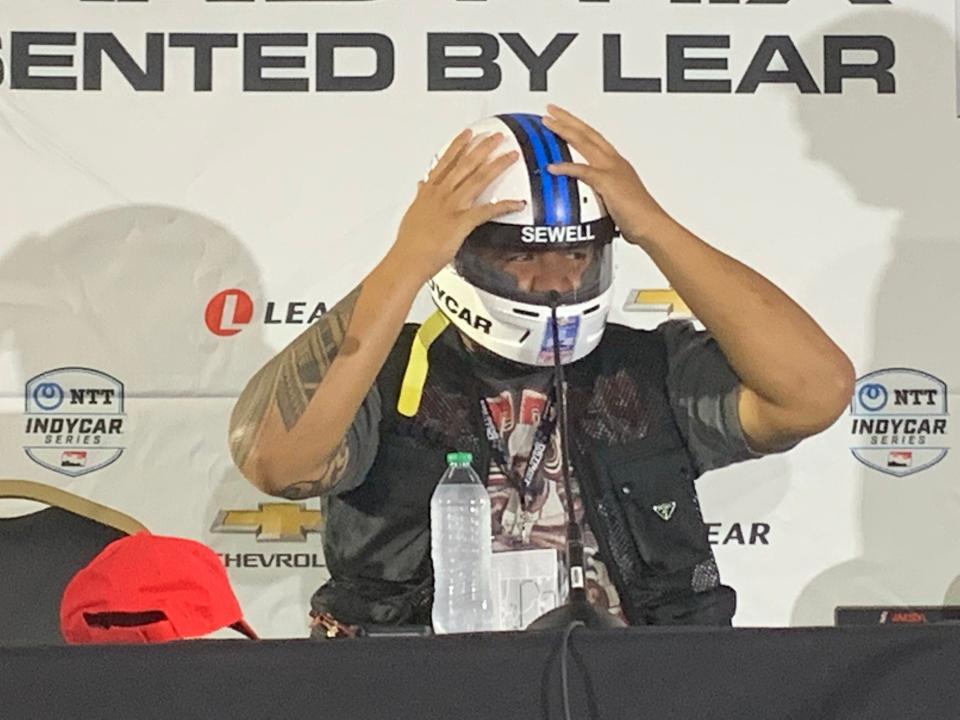 Detroit Lions offensive lineman Penei Sewell tries on an IndyCar helmet before Sunday's race. Sewell was the grand marshal for the final race on Belle Isle.