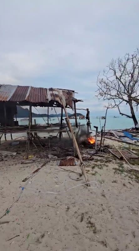 Fire burns next to a house demolished in Tun Sakaran Marine Park, Sabah