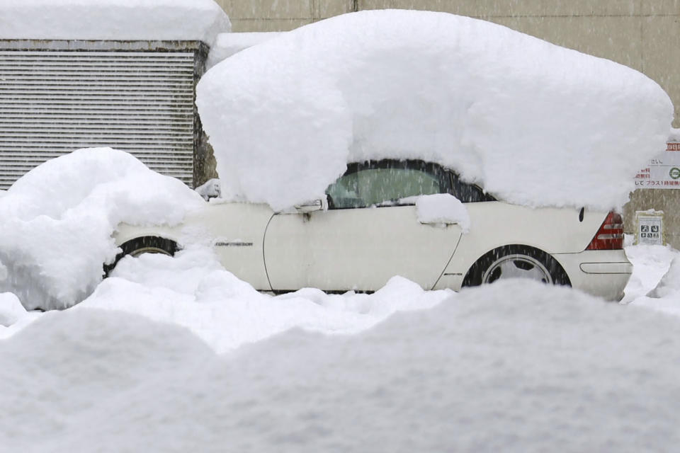 A car is covered in snow after a snowfall Monday, Dec. 19, 2022 in Nagaoka, Niigata prefecture, northern Japan.(Kyodo News via AP)