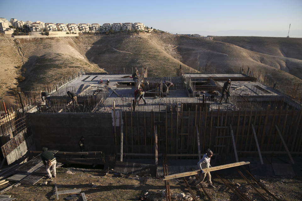 FILE - In this Feb. 7, 2017 file photo, Palestinian laborers work at a construction site in the Israeli settlement of Maale Adumim, near Jerusalem. International Criminal Court's decision authorizing its chief prosecutor to open a war crimes investigation against Israel could soon be reverberating in the Israeli-occupied West Bank. While any potential probe could look at Israeli military campaigns in the Gaza Strip, Israel's half-century campaign of building settlements on occupied lands appears to be especially vulnerable to prosecution. (AP Photo/Oded Balilty, File)