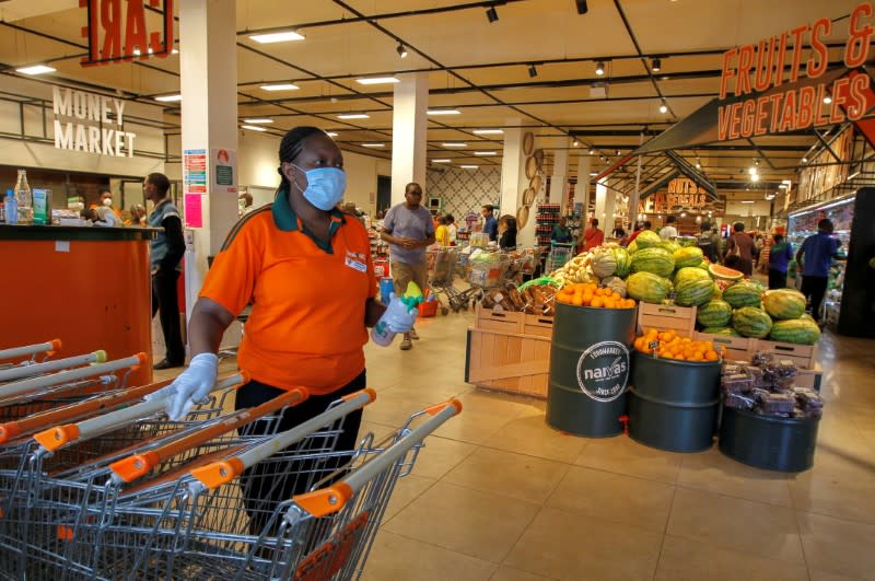 FILE PHOTO: Worker disinfects shopping trolleys as customers shop in the Naivas Supermarket in Nairobi